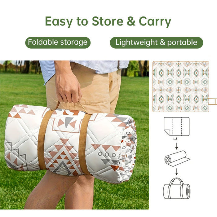 Folded outdoor picnic blanket with carrying straps being held for easy portable storage